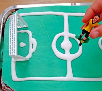 Kinder-DIY-Trends-Fussball-WM-Kuchen Tippkick Figur auf den Fußball WM Kuchen stecken