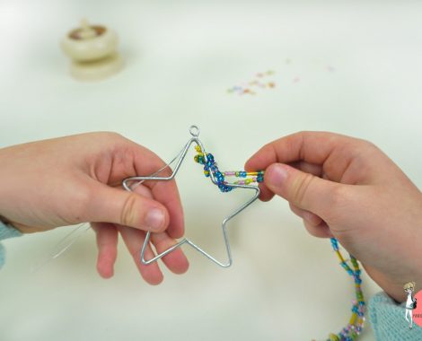 Perlen mit der Perlenmühle auffädeln, dann um einen Drahtstern wickeln