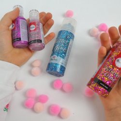 Glitter Glue mit Sternchen und Fäden passen gut zu Pompoms - Bastelidee für den Kindergeburtstag