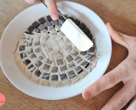 Zwischen den Mosaiksteinen ausfugen mit Fugenmasse und Spatel